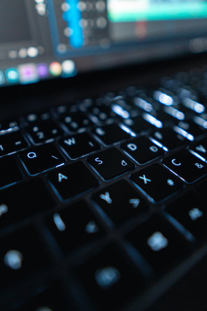A vertical shot of a keyboard of a laptop on a blurred background