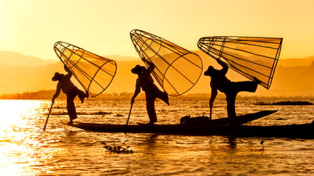 A beautiful shot of some people during the sunset in Myanmar over a seaの写真素材