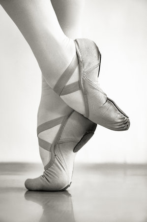A grayscale shot of ballerina's legs in pointe