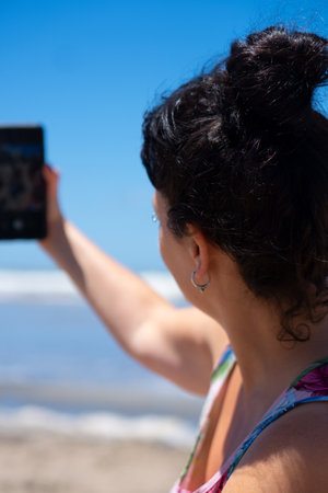 woman taking a selfie on the beach with copy space