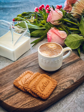 A closeup shot of coffee with milk and cookies with flowers on isolated backgroundの写真素材