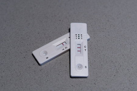 A high angle shot of a positive and negative covid19 antigen test on a tableの写真素材