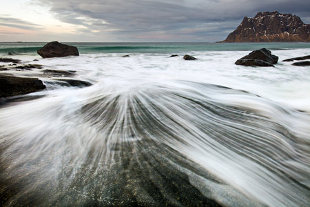 A landscape of the sea with long exposure surrounded by rocks in Lofoten, Norwayの写真素材