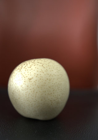 A vertical selective focus shot of an abstract weird egg on a blurry red backgroundの写真素材