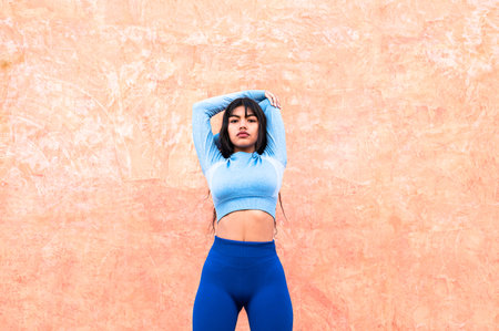 A Attractive Colombian woman dressed in sportswear stretching her muscles after finishing her...