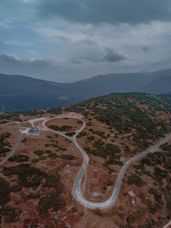 An aerial shot of a country landscape with a serpentine under a gloomy sky