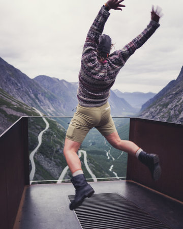 A hiker jumping on a mountain background