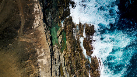 Overhead shot photo of rocks and sea blue waves