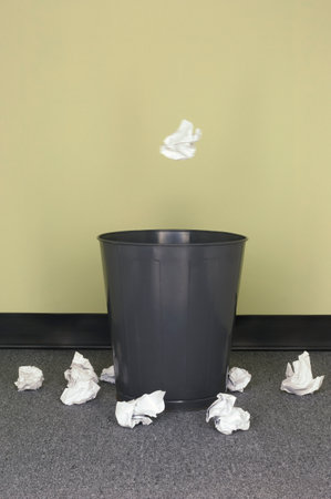 A closeup of wrinkled papers near a trash canの写真素材