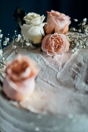 A closeup shot of a vanilla cake decorated with rosesの写真素材