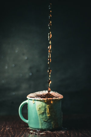 A vertical shot of an overfilled cup of coffeeの写真素材