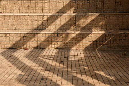 An outdoor brick staircase background with railing shadowの写真素材