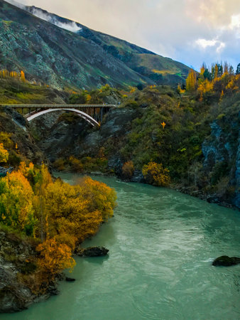 A vertical scenic view of a Kawarau Gorge Suspension Bridge over Kawarau River in New Zealandの写真素材
