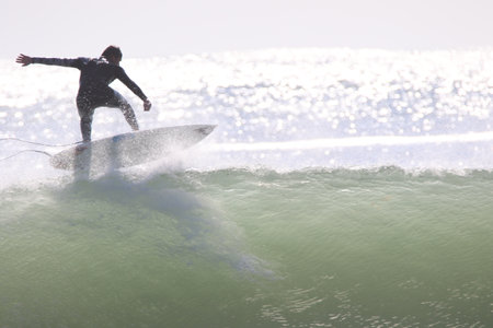 A beautiful shot of a surfer jumping on a huge wave.