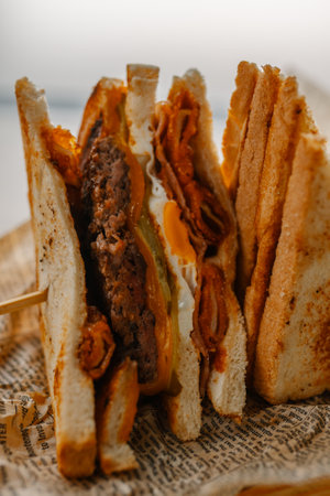 A closeup of delicious sandwiches with meat, cheese, and pickles served at the cafeの写真素材