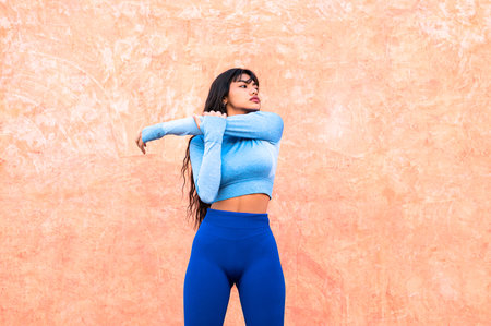 A Attractive Colombian woman dressed in sportswear stretching her muscles after finishing her exerciseの写真素材