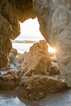 A vertical shot of rocks near the sea at sunsetの写真素材