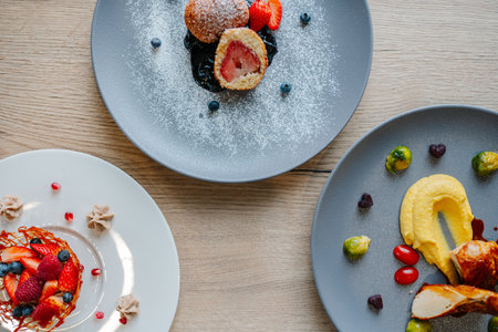 A top-view closeup of fresh fruit desserts in ceramic plates on a wooden surface