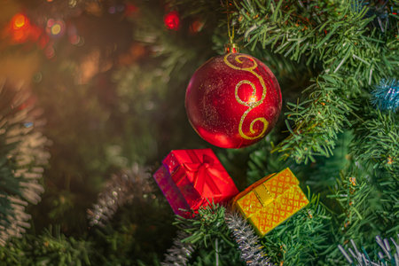 Bright Christmas decorations on a green festive tree: colored balls, garland, tinsel and multi-colored gift boxes.の写真素材