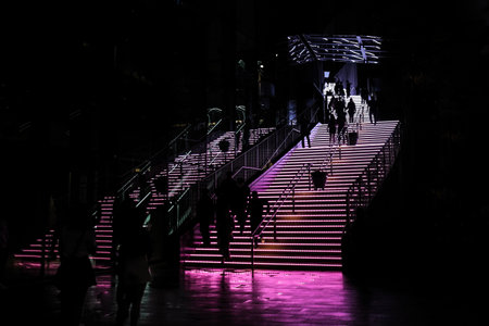 The staircase in the dark interior lighted up with purple color illuminationの写真素材