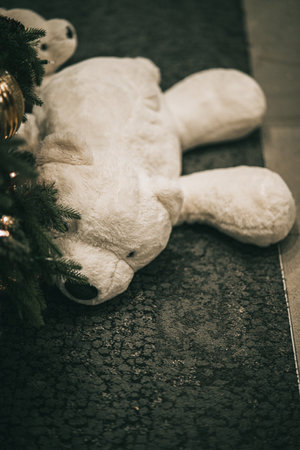 A close up of a teddy bear under Christmas treeの写真素材