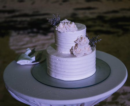A selective focus shot of a wedding cake decorated with flowers