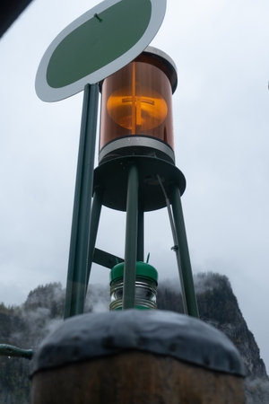 A vertical low angle view of a lamp with orange glass against the sky on a rainy day
