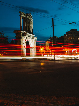 Long exposure red-yellow light trail photo at Hadrian's Arch in Athens, Greece at night