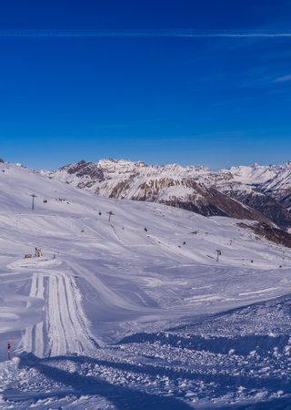 A vertical shot of ski slopes and snowy mountain peaks near Livigno, Italy