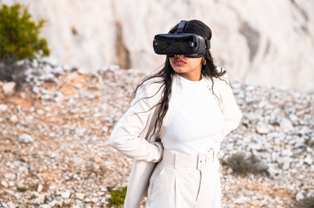 An elegant woman dressed in a white suit using a virtual reality goggles