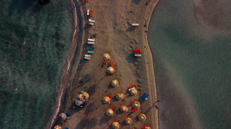 View from above at the beach with sunbeds with water from both sides.の写真素材
