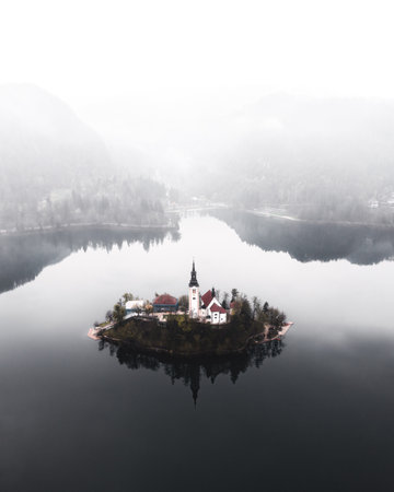 A vertical shot of a building on a lake on a foggy dayの写真素材