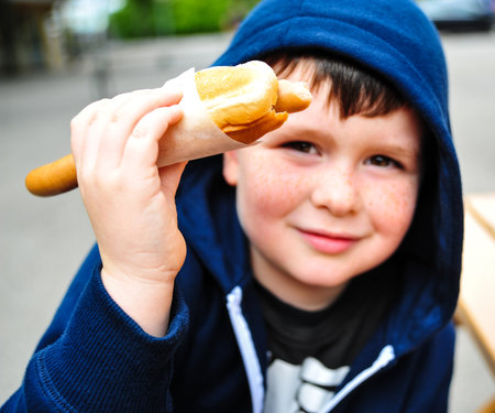 A portrait of a young boy eating a hotdogの写真素材
