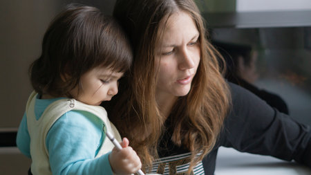 A closeup of the mother holding her child while looking at something.の写真素材