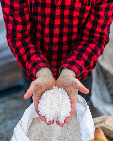 A top view of Organic composted soil amendments in two hands of a person wearing a red checks shirtの写真素材