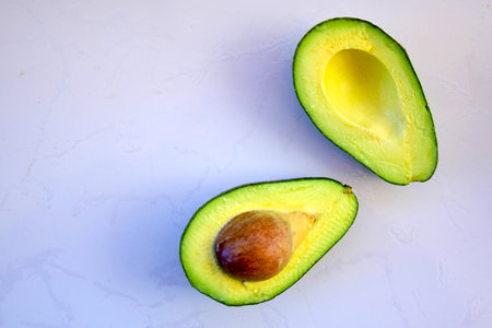 View of Avocado cut in half  on a white boa