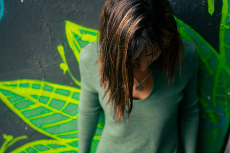 A closeup of the beautiful girl in a green dress posing outdoors.の写真素材