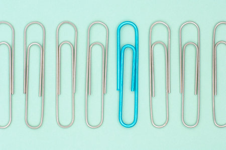A closeup of paper clips on a light green backgroundの写真素材