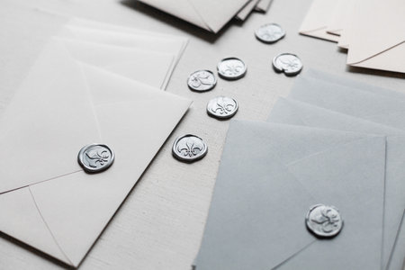A closeup of wedding envelopes with wax seals on a white backgroundの写真素材