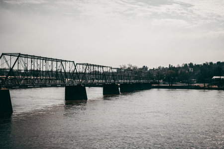 A closeup of a bridge over the river with a cloudy sky backgroundの写真素材