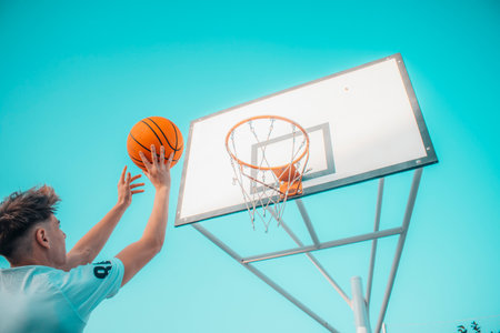 A pretty caucasian boy playing basketball on a playground