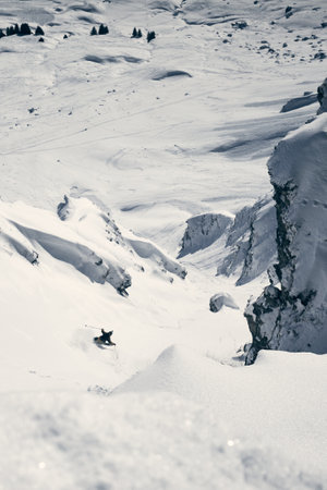 A the skier slips covered with snow on a high mountain descending road
