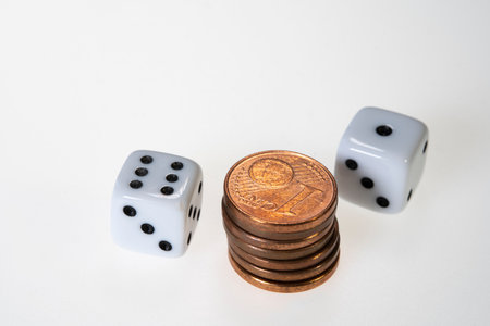Stack of euro cent coins and two white Dice on white Backgroundの写真素材