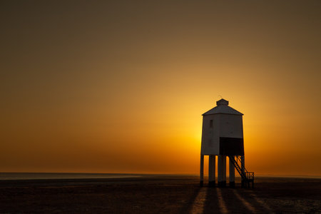 A beautiful golden sunset shining over the Burnham-on-sea Low Lighthouse in Englandの写真素材