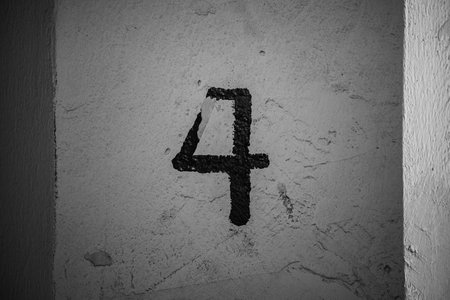 A closeup of a 4 number on a gray wallの写真素材