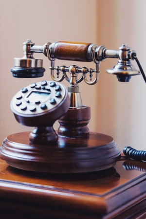 A closeup of vintage wood rotating disc phone on the tableの写真素材