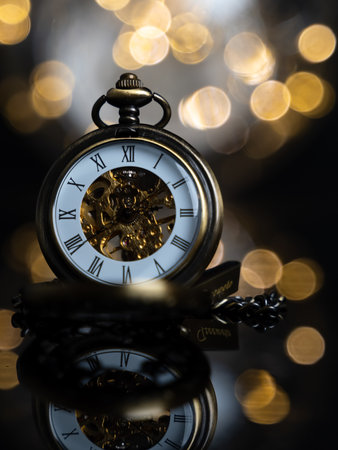 A closeup of gold pocket watches with background of light blursの写真素材