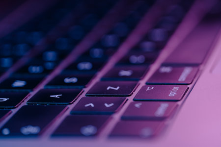 A closeup of an Electronic keyboard with glowing buttons with purple theme lightの写真素材