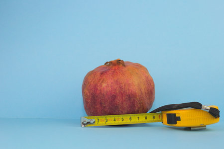 A closeup shot of a pomegranate arond yellow roulette on a blue background