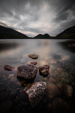 A close-up shot of a rocky shore under the misty cloudy skiesの写真素材